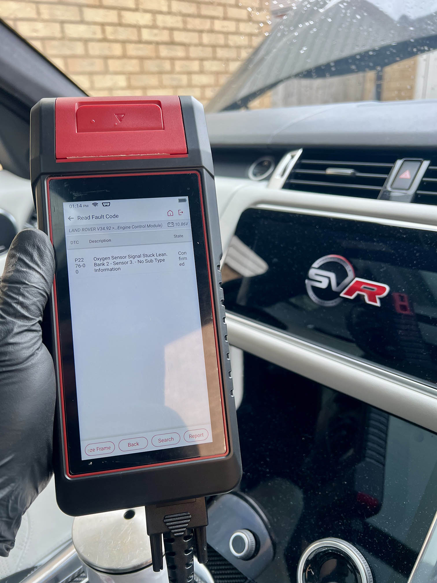 Technician performing vehicle diagnostic check with professional scanner